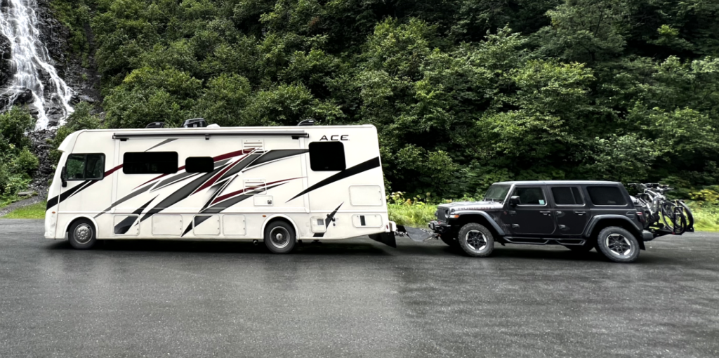 jeep flat-towed behind an RV with bike rack on the jeep