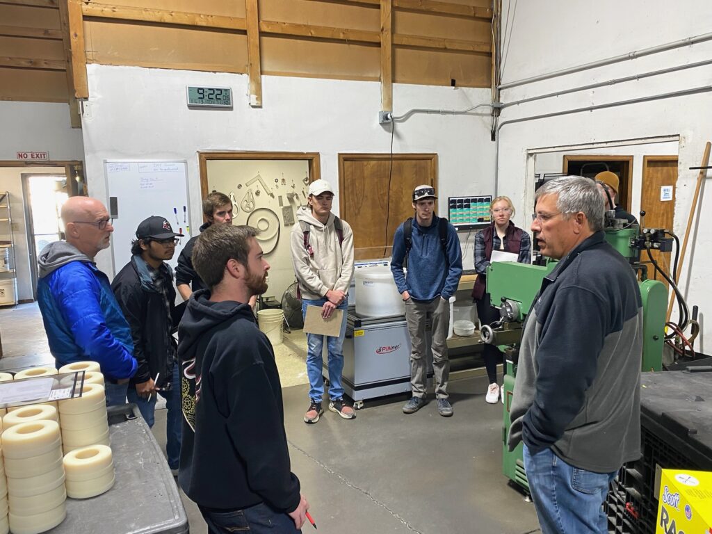 CEO Bryan Wachs and COO JT Westcott give university students a tour of the QuikrStuff factory.