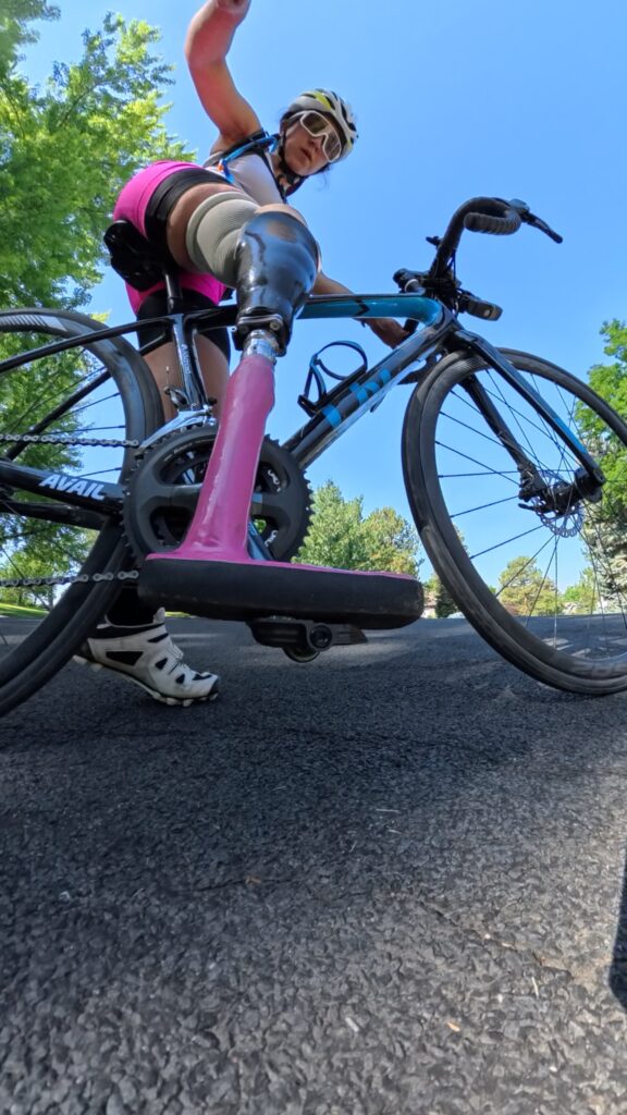 Angelina Martinson mountain bikes with a pink foot she designed herself