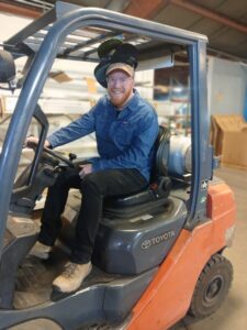 Eric on the fork lift wearing many hats.